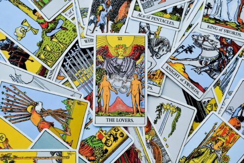 A colorful spread of various tarot cards with The Lovers card prominently displayed.