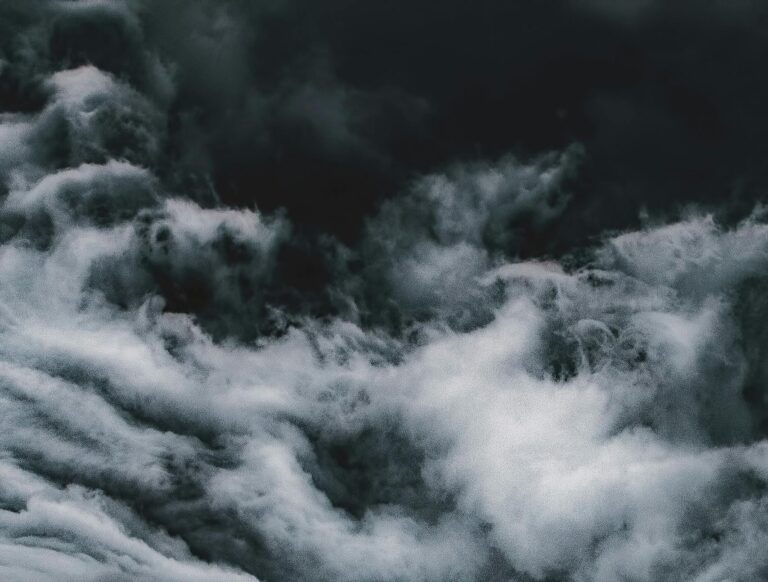 Moody and dramatic close-up of stormy clouds captured from above, showcasing their swirling formations.