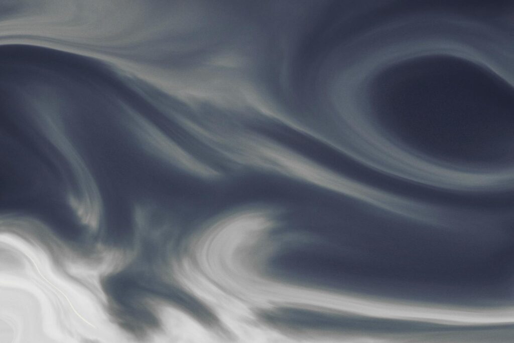 Stunning view of swirling clouds above snow-covered peaks in Trentino-Südtirol, Italy.